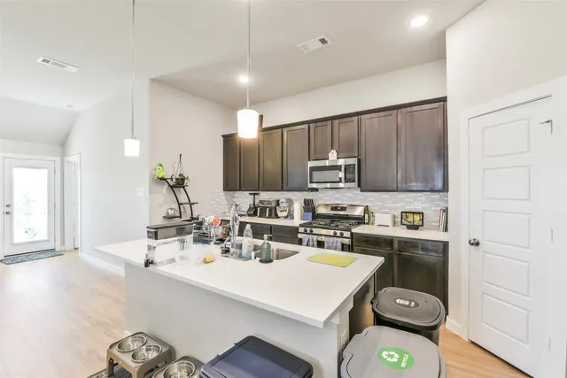 a kitchen with a sink a stove cabinets and wooden floor