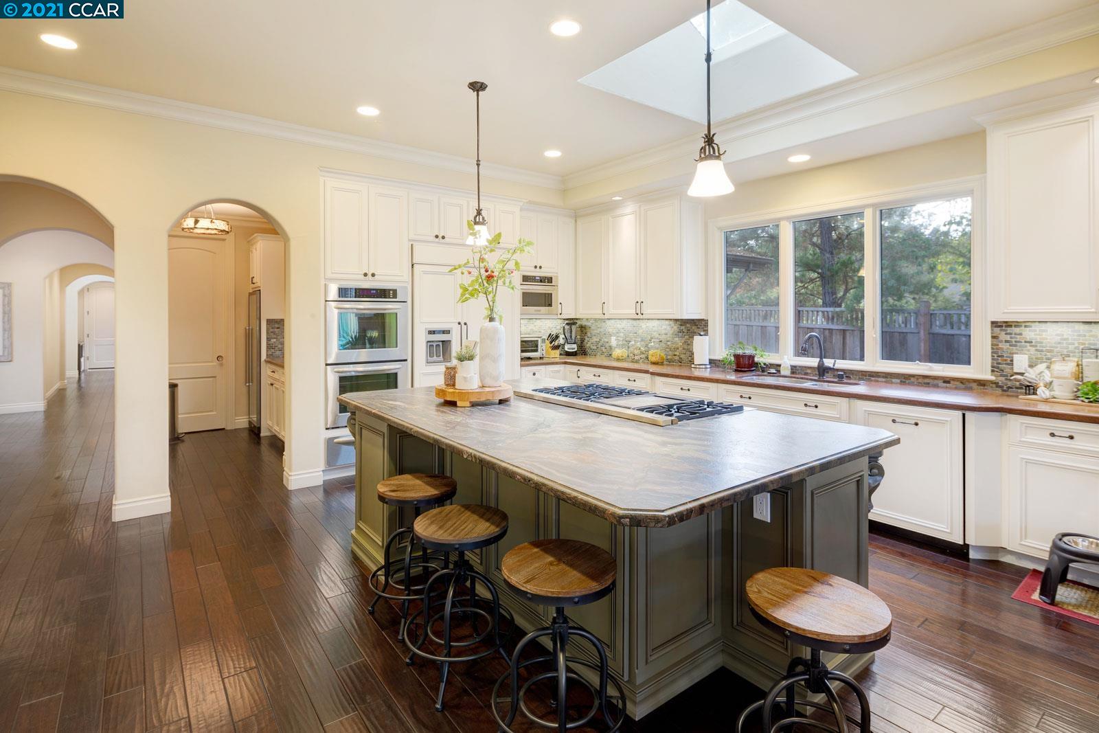Undisclosed Address Diablo, CA 94526 - Photo 21 of 40 a kitchen with stainless steel appliances kitchen island a table chairs in it and wooden floors
