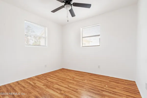 a view of empty room with wooden floor