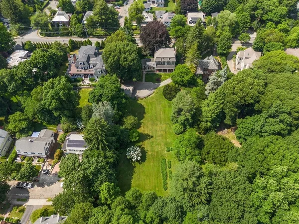 an aerial view of residential house with outdoor space and trees all around