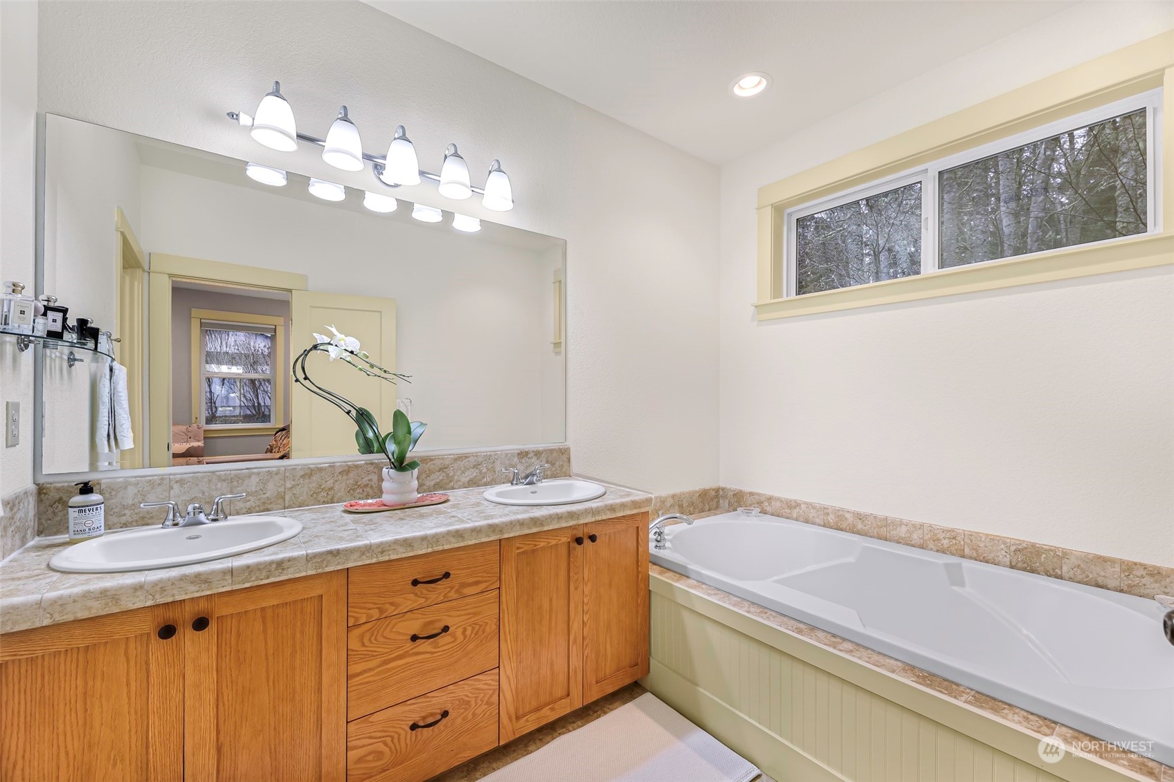 4384 Salmon Run Road Anacortes, WA 98221 - Photo 11 of 34 a bathroom with a granite countertop sink a large mirror a and a shower