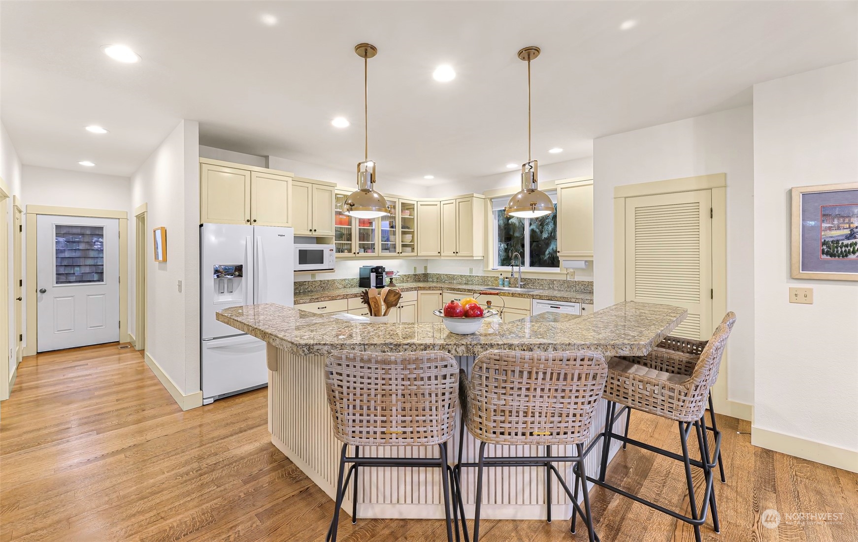4384 Salmon Run Road Anacortes, WA 98221 - Photo 6 of 34 a kitchen with stainless steel appliances kitchen island granite countertop a dining table chairs and white cabinets