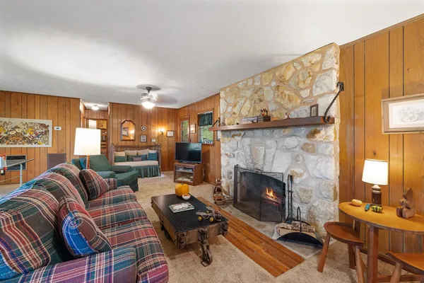 a living room with furniture a fireplace and a large mirror