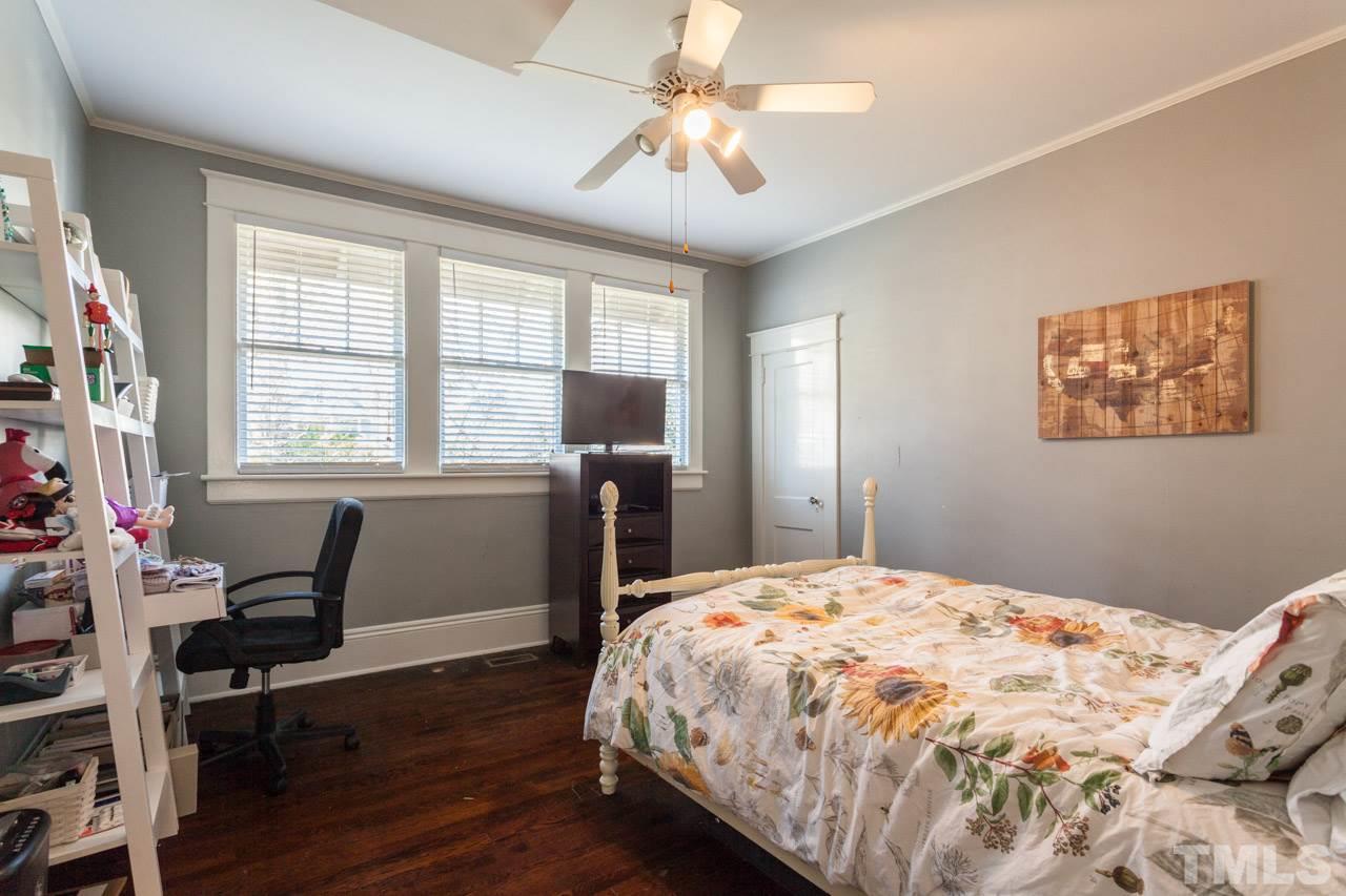 1907 Alexander Road Raleigh, NC 27608 - Photo 12 of 29 a bedroom with a bed and a chandelier