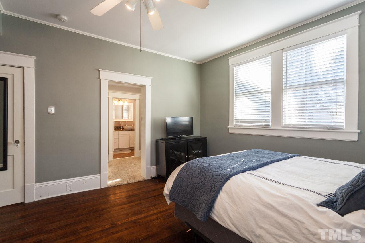 1907 Alexander Road Raleigh, NC 27608 - Photo 14 of 29 a bedroom with a bed and wooden floor