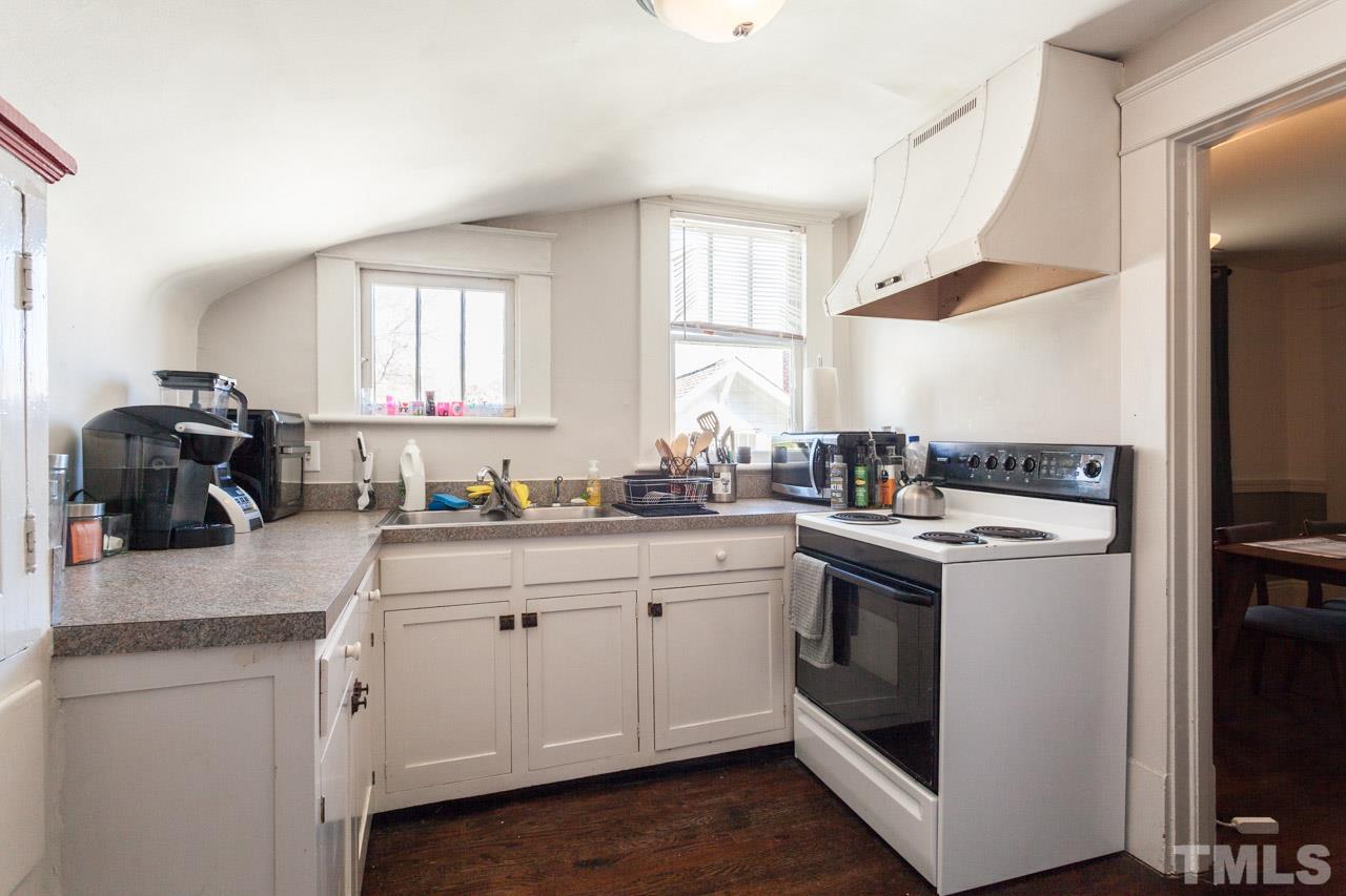 1907 Alexander Road Raleigh, NC 27608 - Photo 24 of 29 a kitchen with white cabinets and white appliances