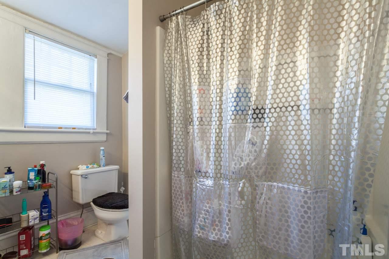 1907 Alexander Road Raleigh, NC 27608 - Photo 26 of 29 a bathroom with a sink a toilet and shower curtain