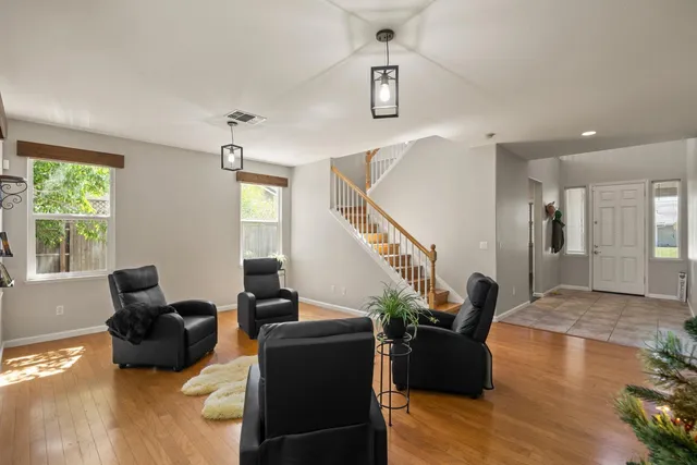 a living room with furniture floor to ceiling window and wooden floor