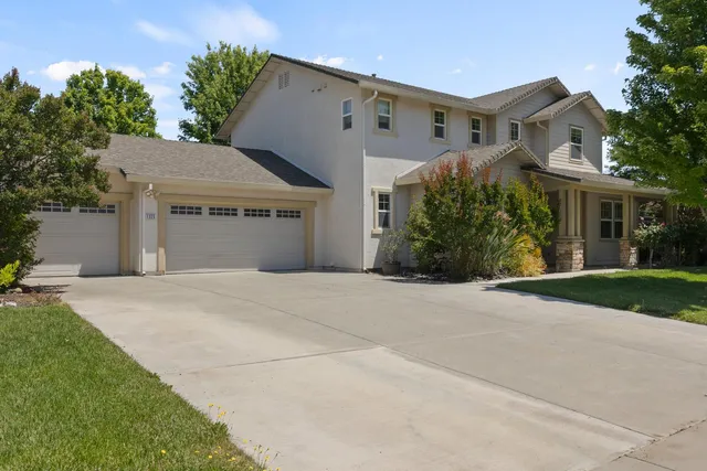 a front view of a house with a yard and a garage
