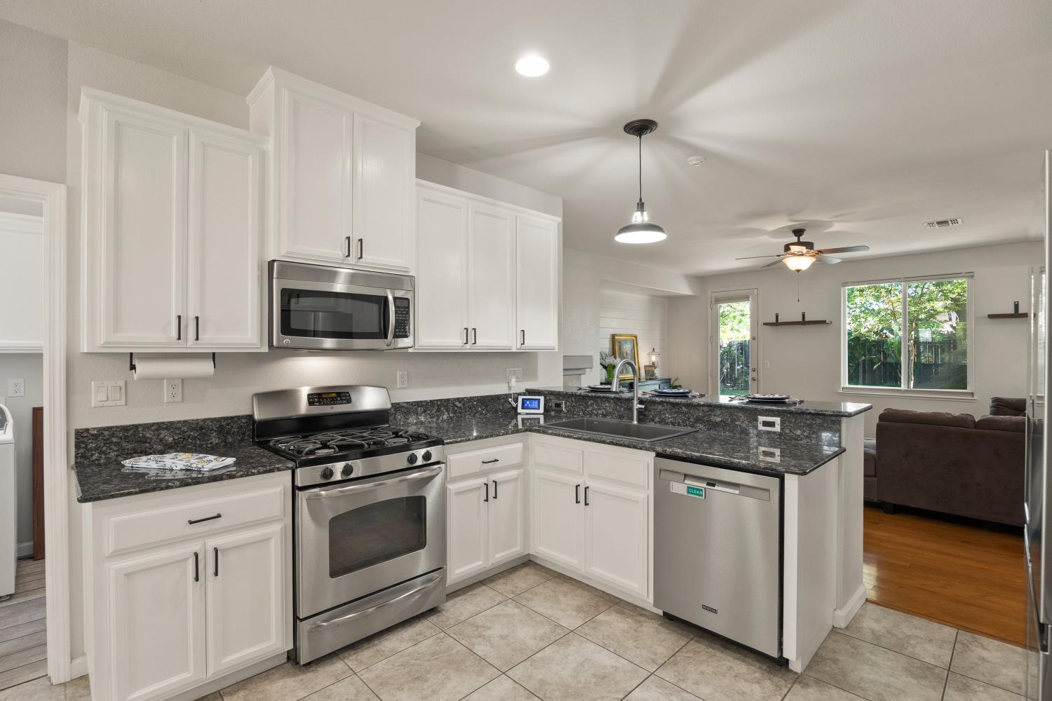 1325 Coby Lane Orland, CA 95963 - Photo 8 of 36 a kitchen with granite countertop white cabinets and white appliances