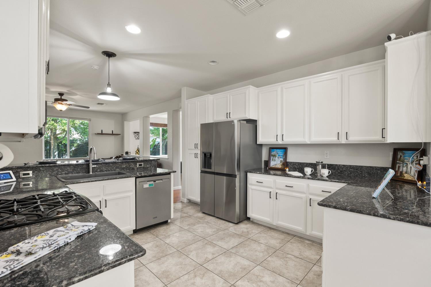 1325 Coby Lane Orland, CA 95963 - Photo 9 of 36 a kitchen with a sink a stove a refrigerator and white cabinets