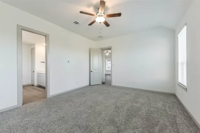 an empty room with fan and windows