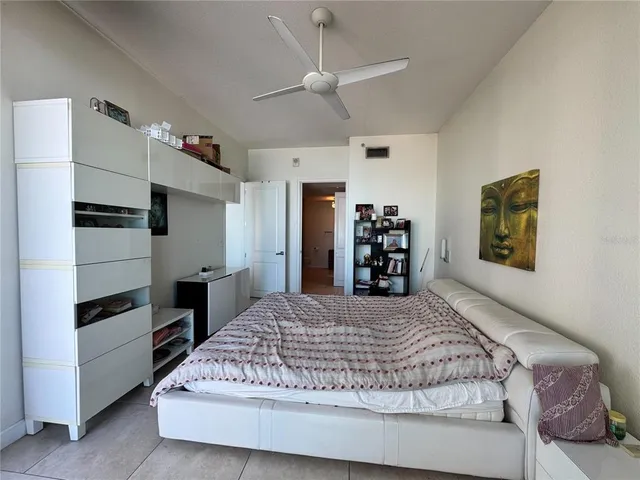 a bedroom with a large bed and a flat tv screen