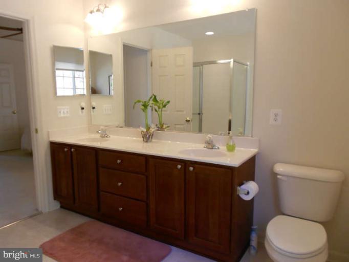 3025 Raking Leaf Drive Abingdon, MD 21009 - Photo 20 of 26 a bathroom with a double vanity sink toilet and a mirror