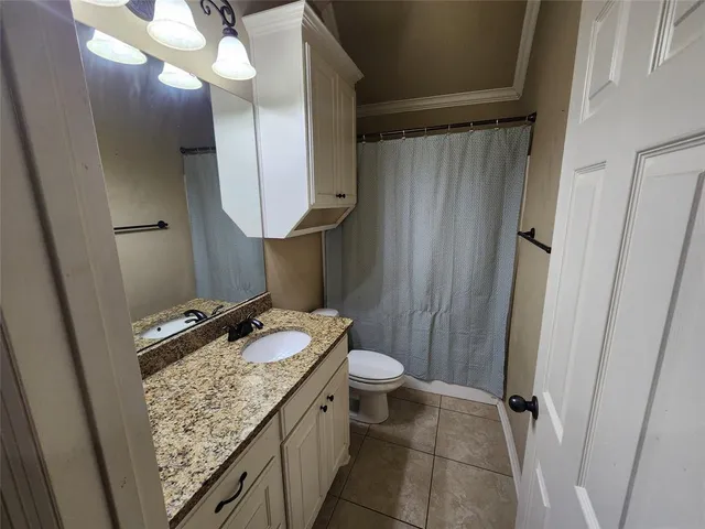 a bathroom with a granite countertop sink a toilet and a mirror