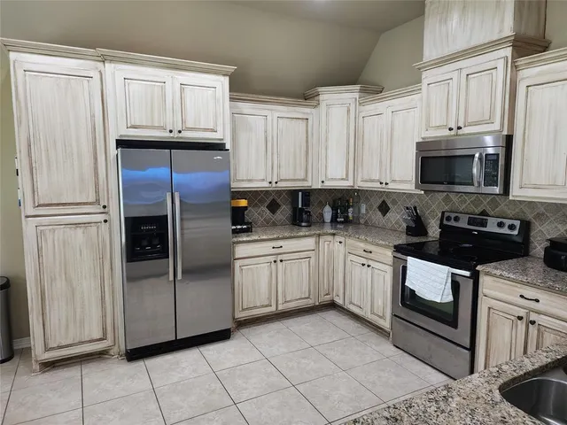 a kitchen with stainless steel appliances granite countertop a refrigerator sink and cabinets