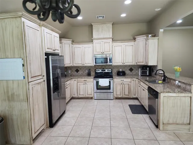 a kitchen with stainless steel appliances granite countertop a refrigerator and a stove