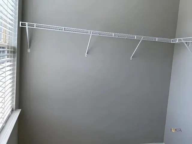 a view of a room with racks on the wall and shower