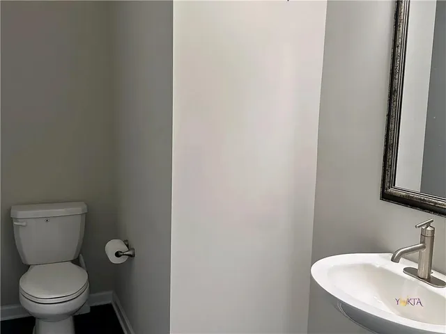 a bathroom with a toilet a sink and mirror
