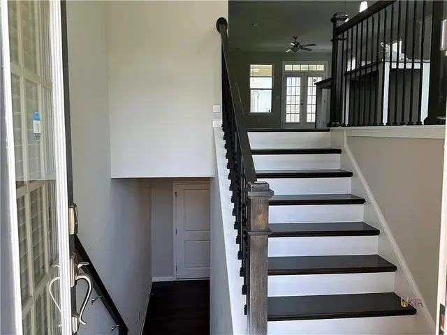 a view of staircase with lots of frames on wall and a window