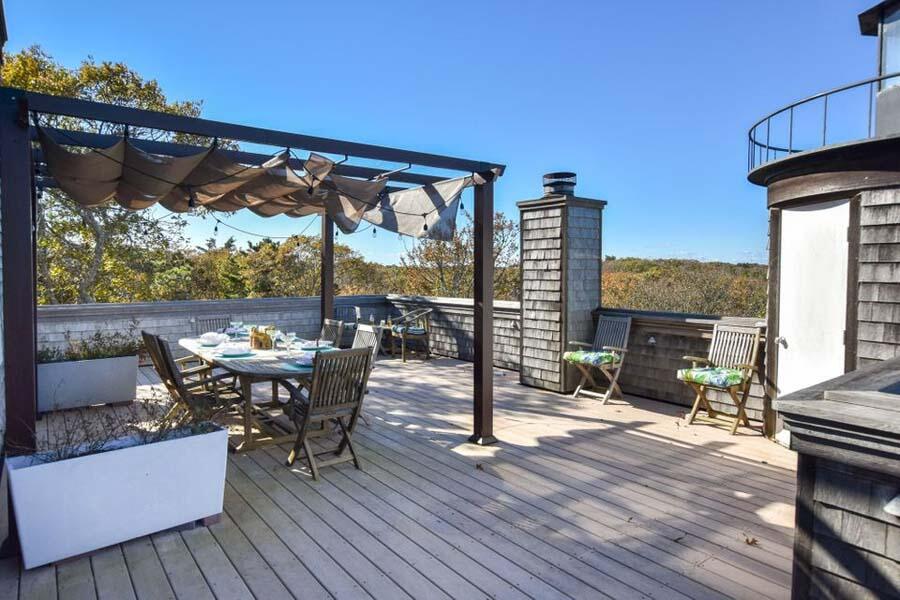 16 Thistlemore Road Provincetown, MA 02657 - Photo 8 of 27 a view of a roof deck with table and chairs a barbeque with wooden floor and fence
