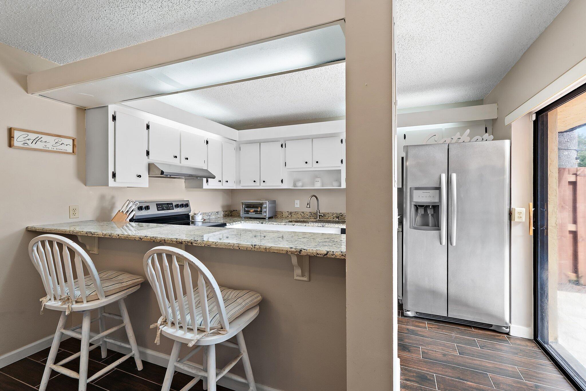 825 Center Street, Unit 30A Jupiter, FL 33458 - Photo 13 of 33 a kitchen with stainless steel appliances granite countertop a refrigerator and a stove top oven