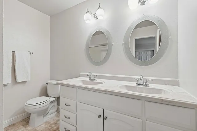 a bathroom with a toilet a sink and a mirror