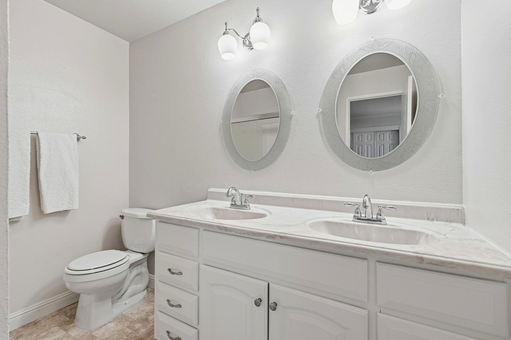1643 West Swain Road Stockton, CA 95207 - Photo 21 of 27 a bathroom with a toilet a sink and a mirror