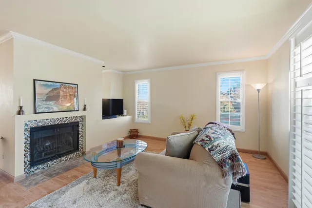 a living room with furniture a flat screen tv and a fireplace