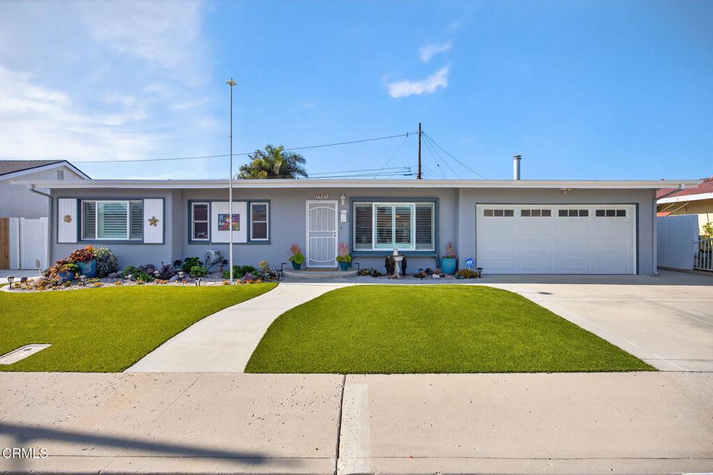 a view of a house with a yard and sitting area