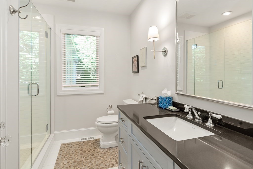 108 Nehoiden Road Newton, MA 02468 - Photo 30 of 42 a bathroom with a granite countertop sink a toilet a mirror and a shower