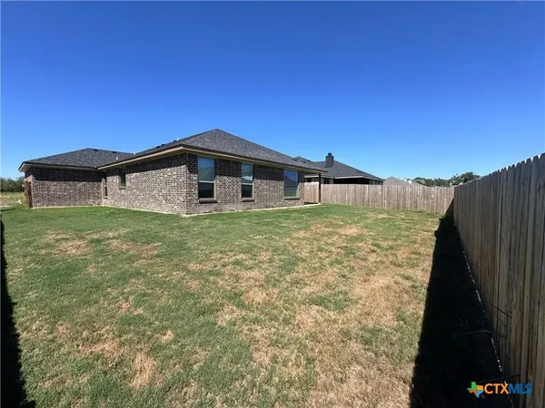 a blue swimming pool is sitting in front of a yard