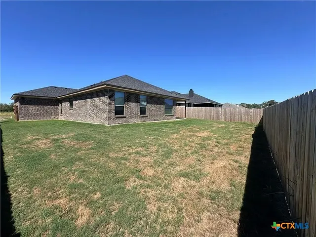 a blue swimming pool is sitting in front of a yard