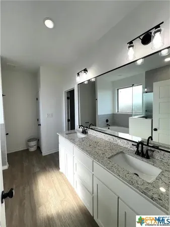 a bathroom with a granite countertop sink a mirror and toilet