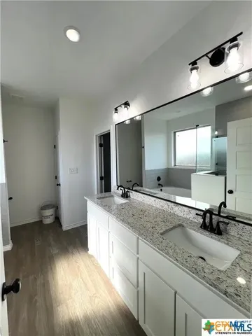 a bathroom with a granite countertop sink a mirror and toilet