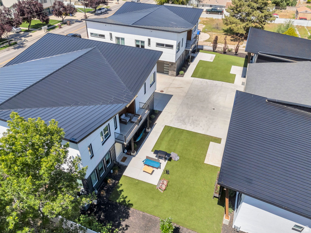 7045 South 300 East Midvale, UT 84047 - Photo 41 of 49 Contemporary multi-level residence featuring a dark metal roof, white and dark panel siding, and a balcony with dark railing