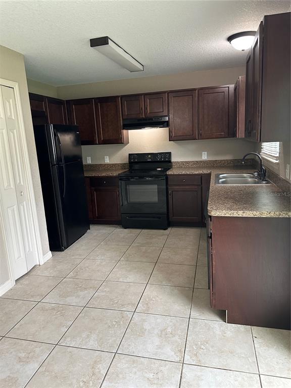 5663 Northwest 57th Street Ocala, FL 34482 - Photo 6 of 19 a kitchen with granite countertop a refrigerator and a stove top oven
