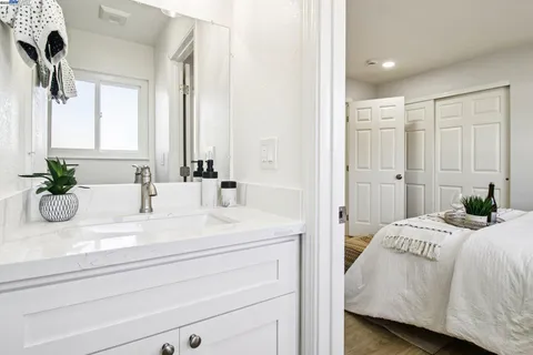 a bathroom with a granite countertop sink a mirror and a shower