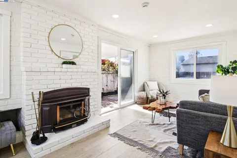 a living room with furniture a fireplace and a large mirror