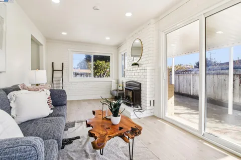a living room with furniture a large window and a fireplace