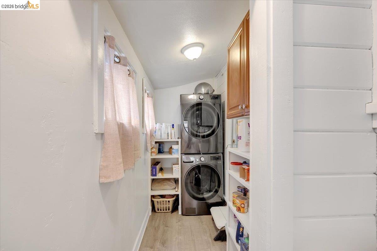 26144 Long Barn Road Long Barn, CA 95335 - Photo 23 of 42 Laundry area featuring a stacked washer and dryer, wood-finish flooring, and built-in shelving
