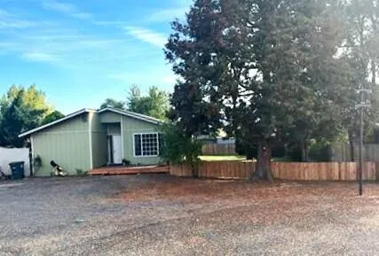 a view of a house with a backyard and tree