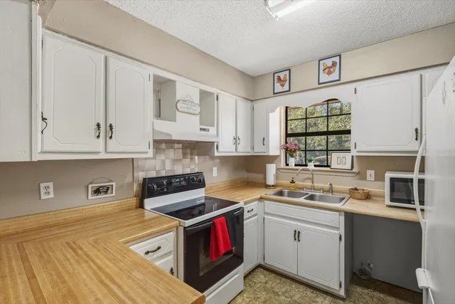a kitchen with a sink cabinets and a window