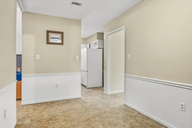 an empty room with windows and cabinet