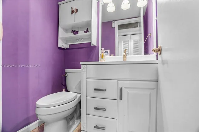a bathroom with a sink a toilet a mirror and vanity