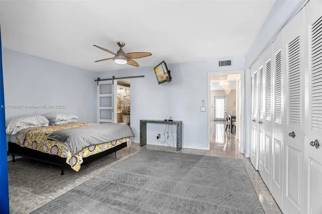 a spacious bedroom with a bed and a chandelier