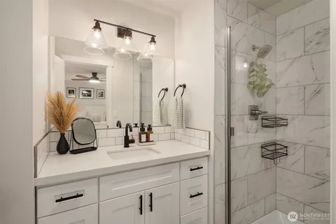 a bathroom with a double vanity sink a shower and a mirror