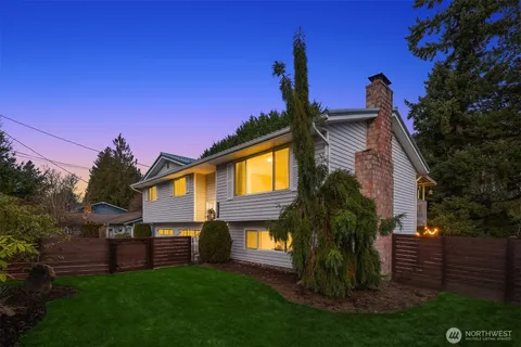 a front view of a house with a garden and yard