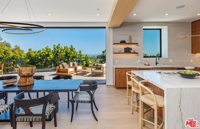 a kitchen with stainless steel appliances a table and chairs in it