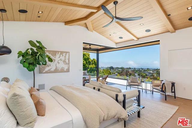 a bedroom with furniture and a large window